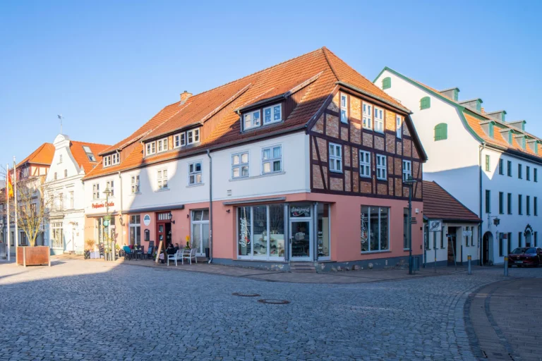 Blick auf ein restauriertes Fachwerkhaus mit Geschäften auf einem Marktplatz