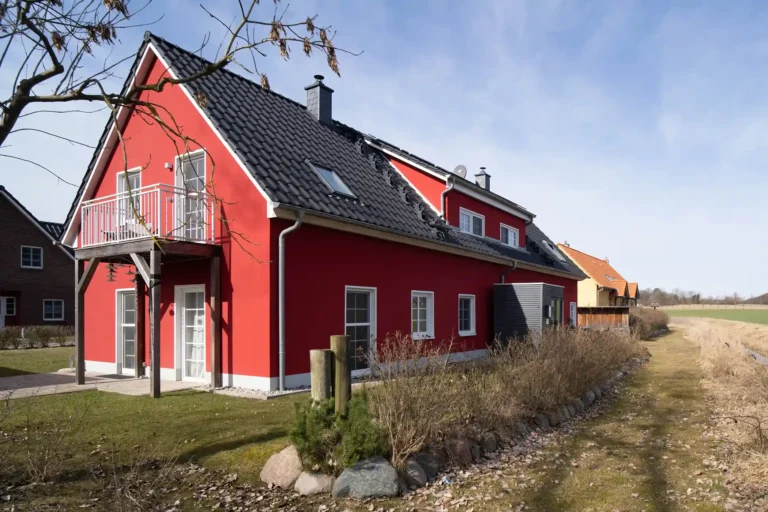 Ein rotes Ferienhaus mit Feld im Hintergrund