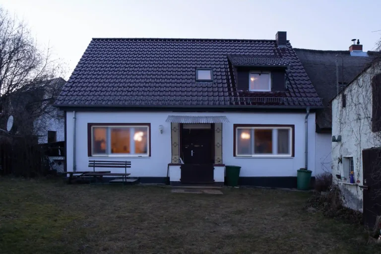 Ein weißes Haus mit rotbraunem Dach in der Dämmeriung