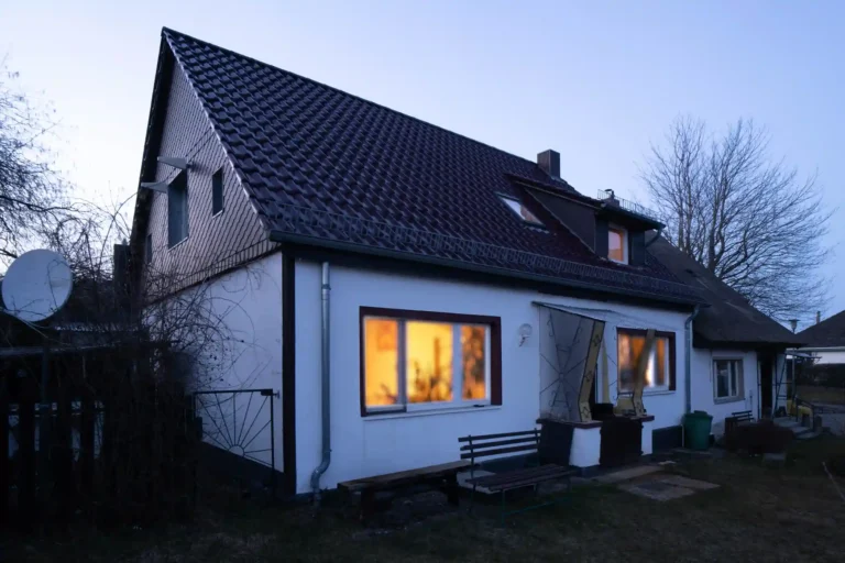 Ein weißes Haus mit rotbraunem Dach in der Dämmeriung