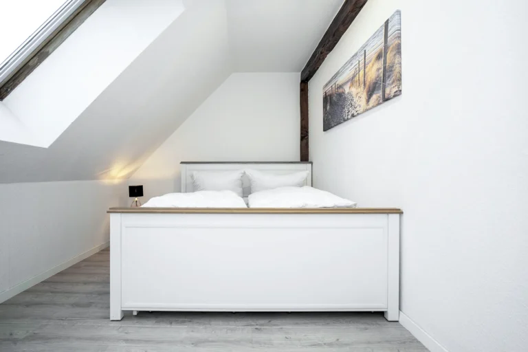 Blick in das helle Schllafzimmer einer Dachgeschosswohnung mit Dachschrägen