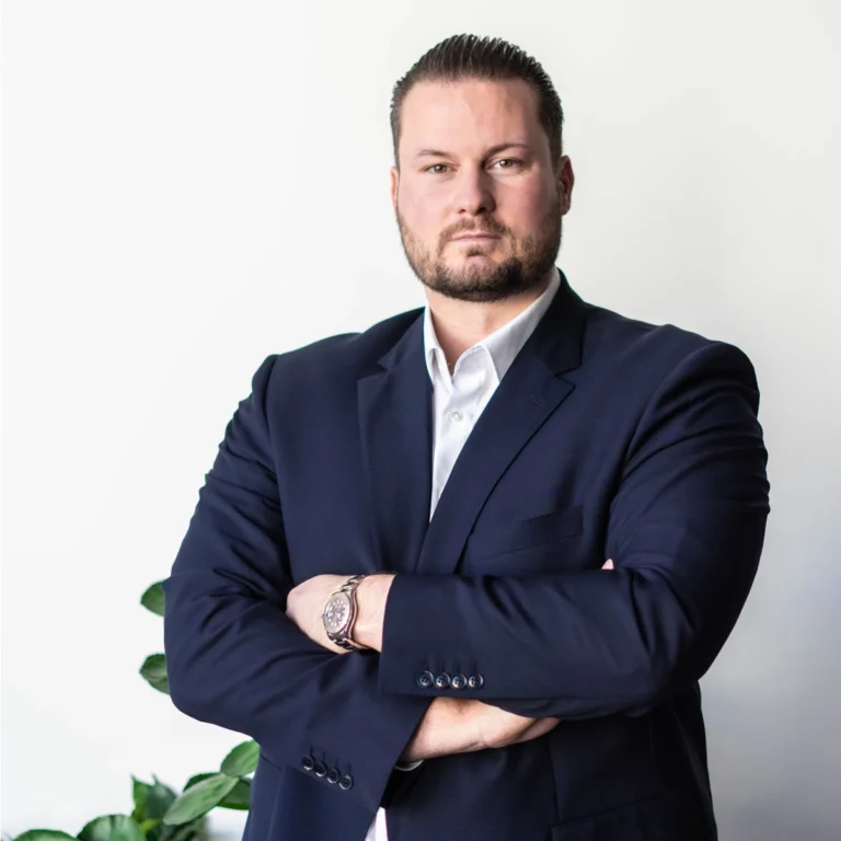 Ein Mann in einem Anzug blickt ernst in die Kamera.