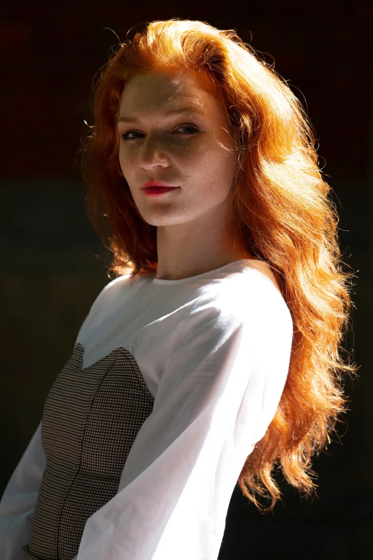 Portrait einer jungen Frau mit roten Haaren im warmen Seitenlicht