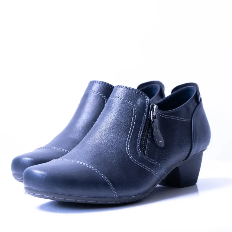 Ein paar dunkelblaue Damenschuhe mit flachem Absatz auf weißem Untergrund