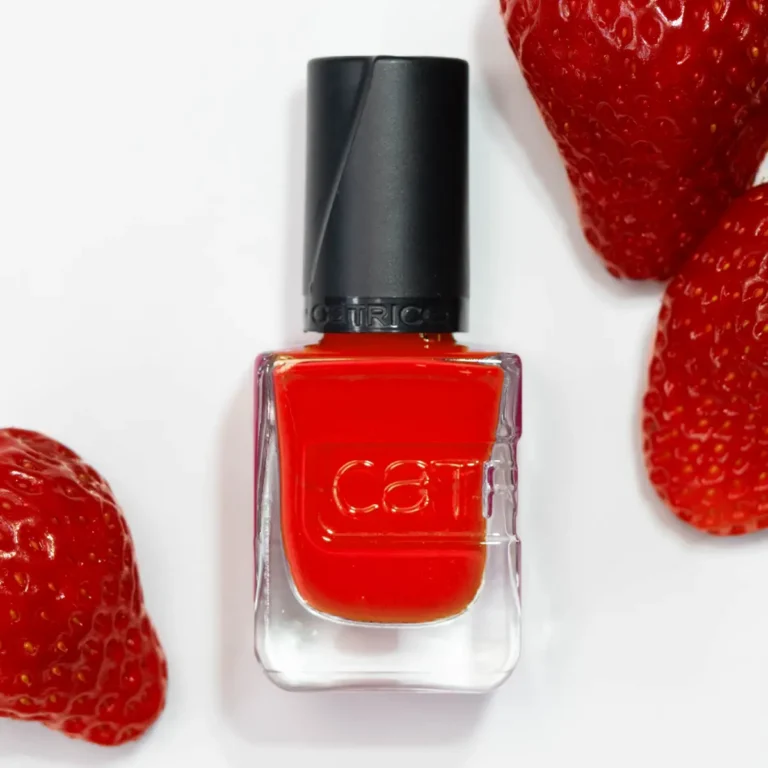 Eine Flasche mit rotem Nagellack und Erdbeeren