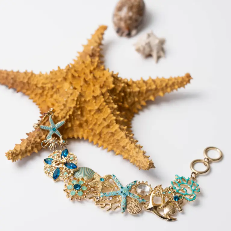 Ein Armband mit Muscheln und Seesternen auf einem echten Seestern