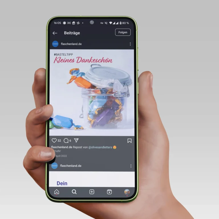 Ein Smartphone mit einem Social Media Beitrag, Es ist ein Glas mit Schokoladenpralinen zu sehen.